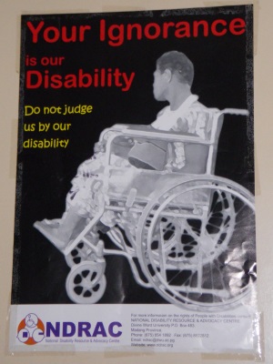 Picture of an advocacy poster produced by the National Disability Resource and Advocacy Centre, Papua New Guinea. The poster shows a man sitting in a wheelchair in profile. The poster reads "Your ignorance is our disability; Do not judge us by our disability".
